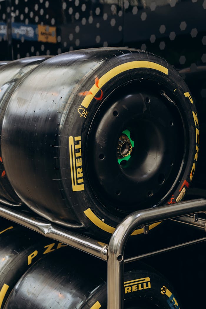 A detailed shot of Pirelli racing tires stacked on a metal rack indoors, showing branding and treads.